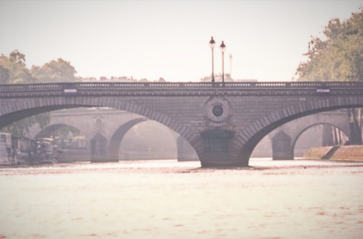 Stone bridge over the Seine River in Paris at sunrise, symbolizing the in-between transitions of expat life.