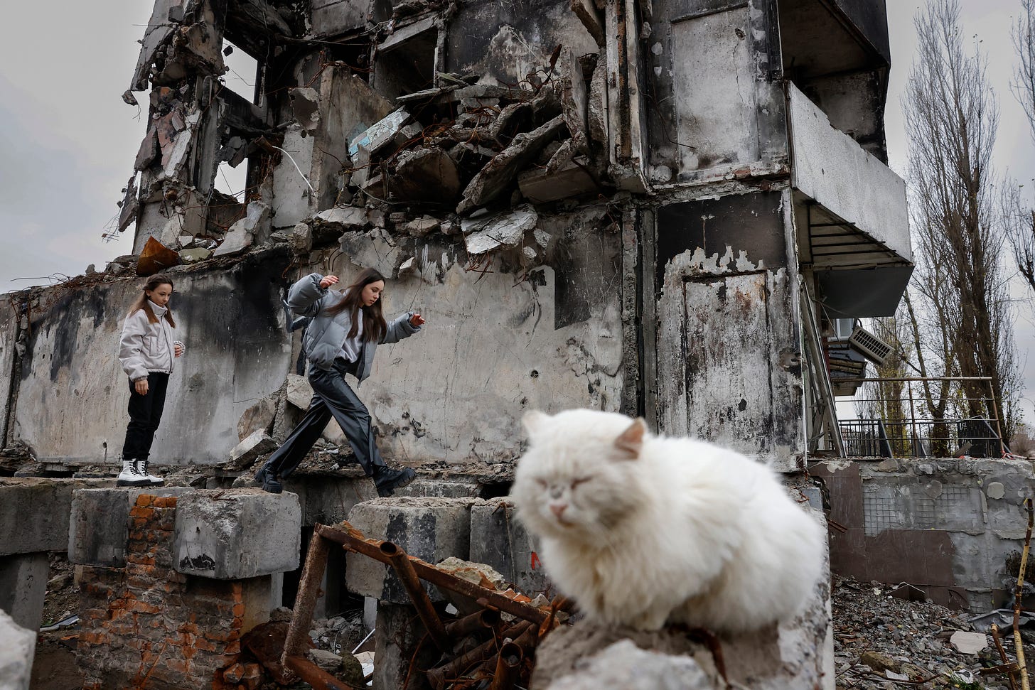 BORODYANKA, UKRAINE - NOVEMBER 14: Girls pass a destroyed building on November 14, 2022 in Borodyanka, Ukraine. In recent days, Russia has retreated from the Ukrainian city of Kherson, allowing Ukraine to reclaim swaths of nearby territory occupied since shortly after the Russian invasion on February 24, 2022. (Photo by Jeff J Mitchell/Getty Images)