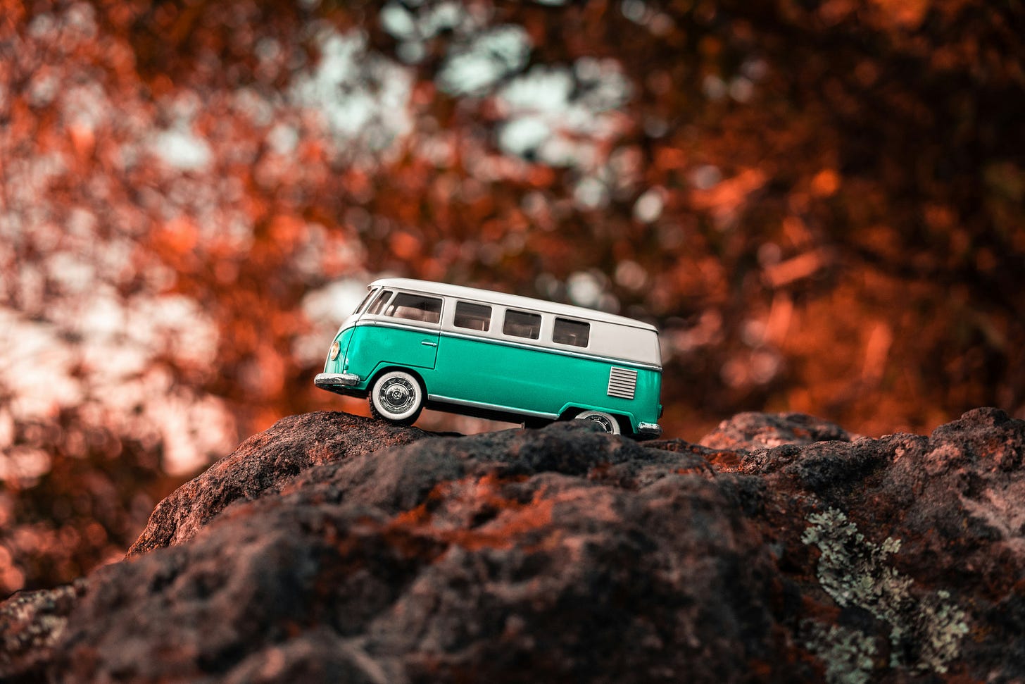 A toy VW camper van in a wooded setting.