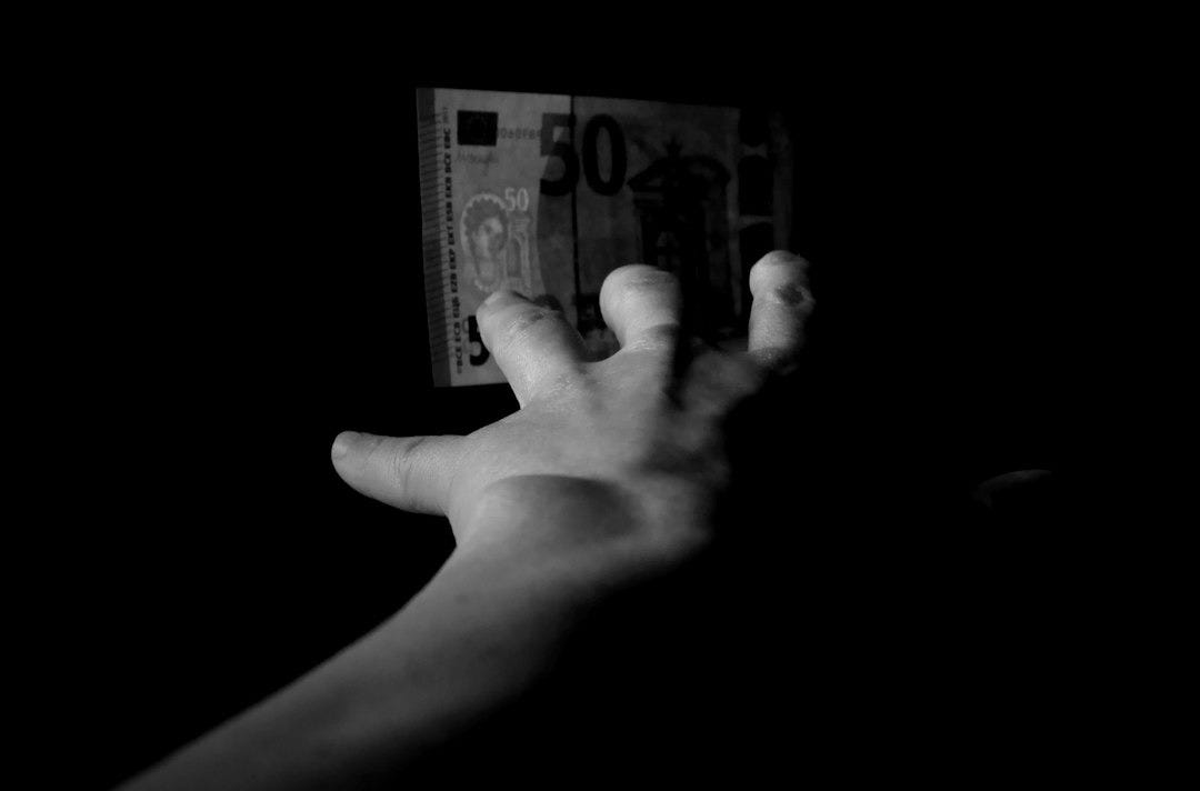 hand reaching for a 50 dollar bill