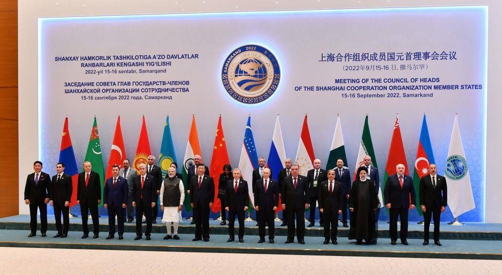A group of people standing in front of a sign

Description automatically generated with low confidence