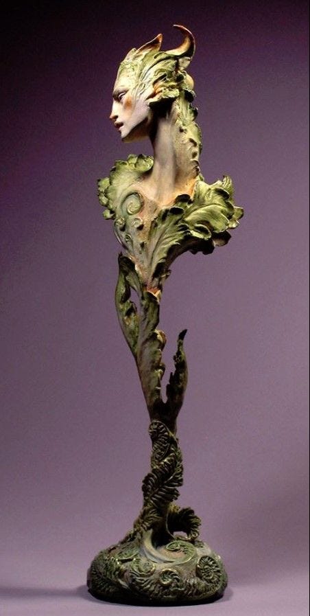 This may contain: a sculpture of a woman's head on top of a leafy plant