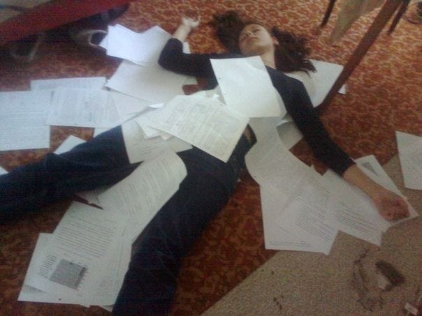 This may contain: a woman laying on the floor covered in papers This may contain: a woman laying on the floor covered in papers