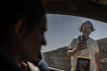 An Israeli settler filming cars on the road approaching the besieged houses in Qusra last week.