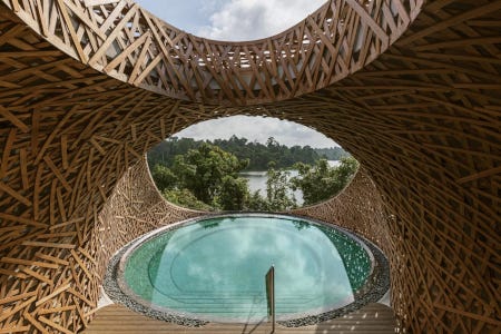 Piscine privée circulaire, turquoise, surplombée d'arceaux en bois