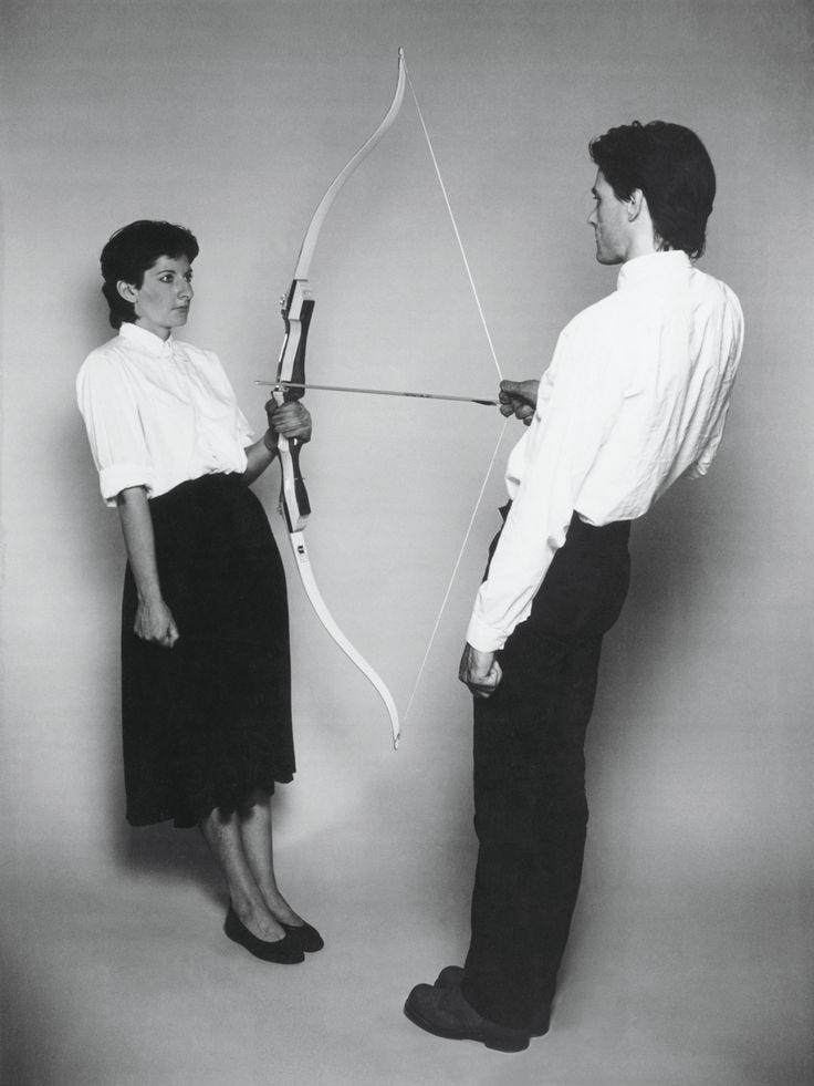 This may contain: a man and woman standing next to each other with an arrow in front of them