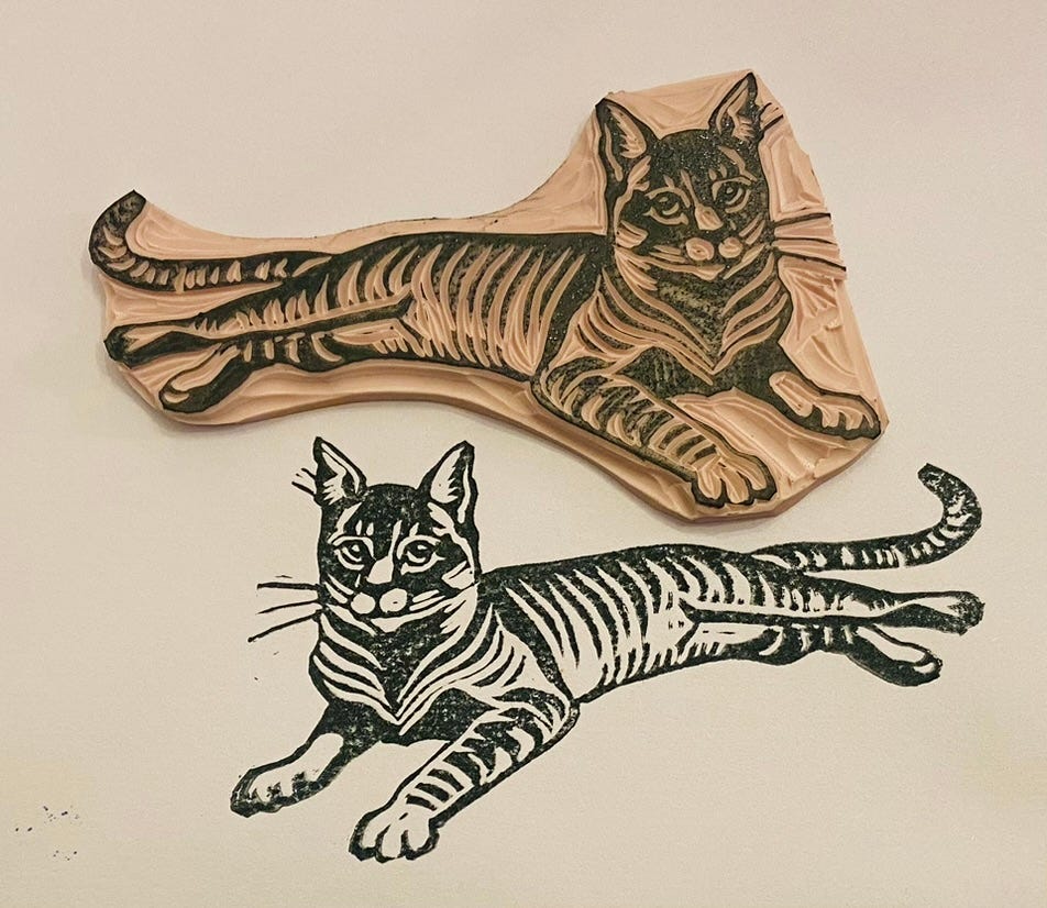 Rubber stamp carving of a striped black and white cat with the print below it.
