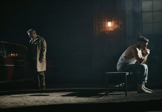 As Willy Loman, Nathan Lane stands by his car, facing one direction, while Christopher Abbott, as Biff, sits on a bench facing the other direction As Willy Loman, Nathan Lane stands by his car, facing one direction, while Christopher Abbott, as Biff, sits on a bench facing the other direction