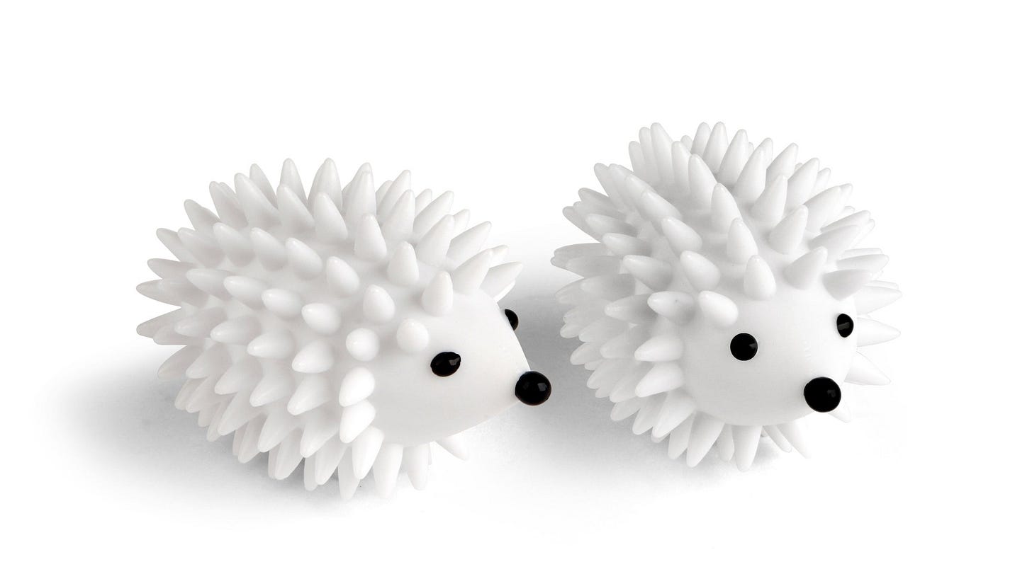 Two white dryer balls shaped like hedgehogs