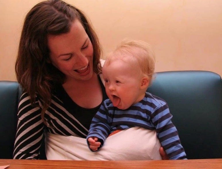 Graham, under one year old, sits in a sling in my lap in a cafe booth. Graham, under one year old, sits in a sling in my lap in a cafe booth.