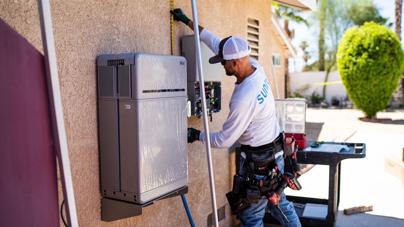 A worker uses a tape measure next to electrical boxes installed on a home. A worker uses a tape measure next to electrical boxes installed on a home.