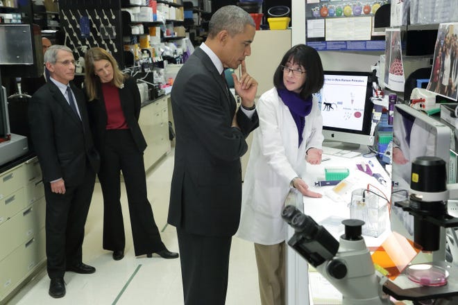 President Barack Obama learns about the results of the experimental Ebola vaccine, which just completed Phase 1 clinical trials, from Dr. Nancy Sullivan, Chief of the National Institute of Allergy and Infectious Diseases Vaccine Research Center Biodefense Research Section. HHS Secretary Sylvia Burwell and NIAID Director Dr. Anthony Fauci accompanied the tour.