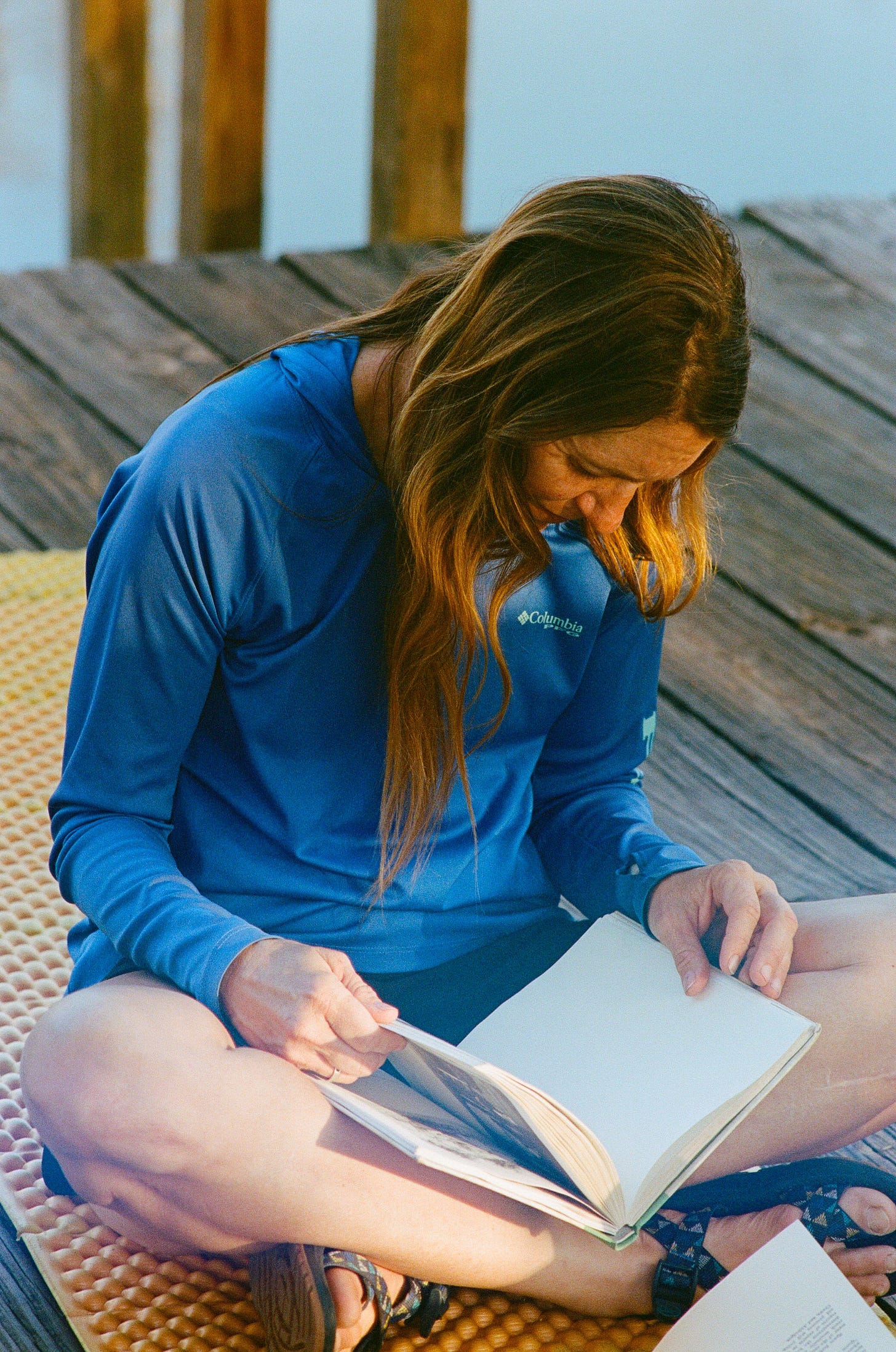 A person sitting on a deck reading a book

AI-generated content may be incorrect.