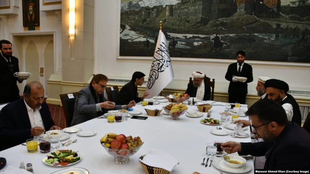 A group of people sitting around a table with food

Description automatically generated with medium confidence