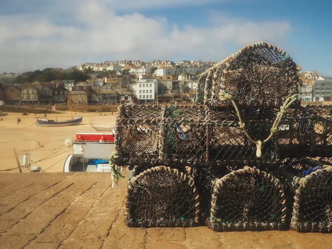 Lobster pots in front of a beach and port behind