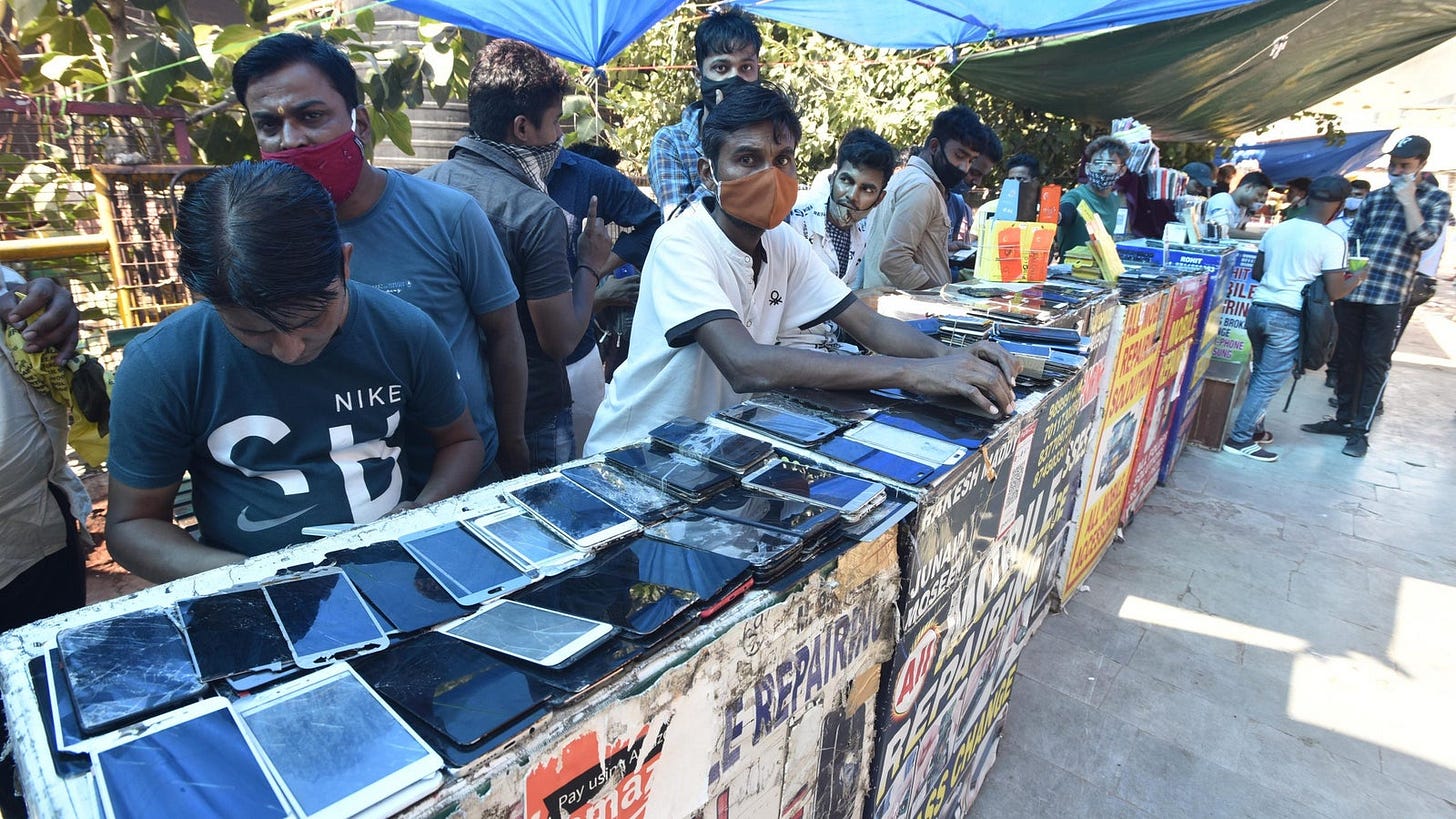 A photo of men selling used phones at a market in India.