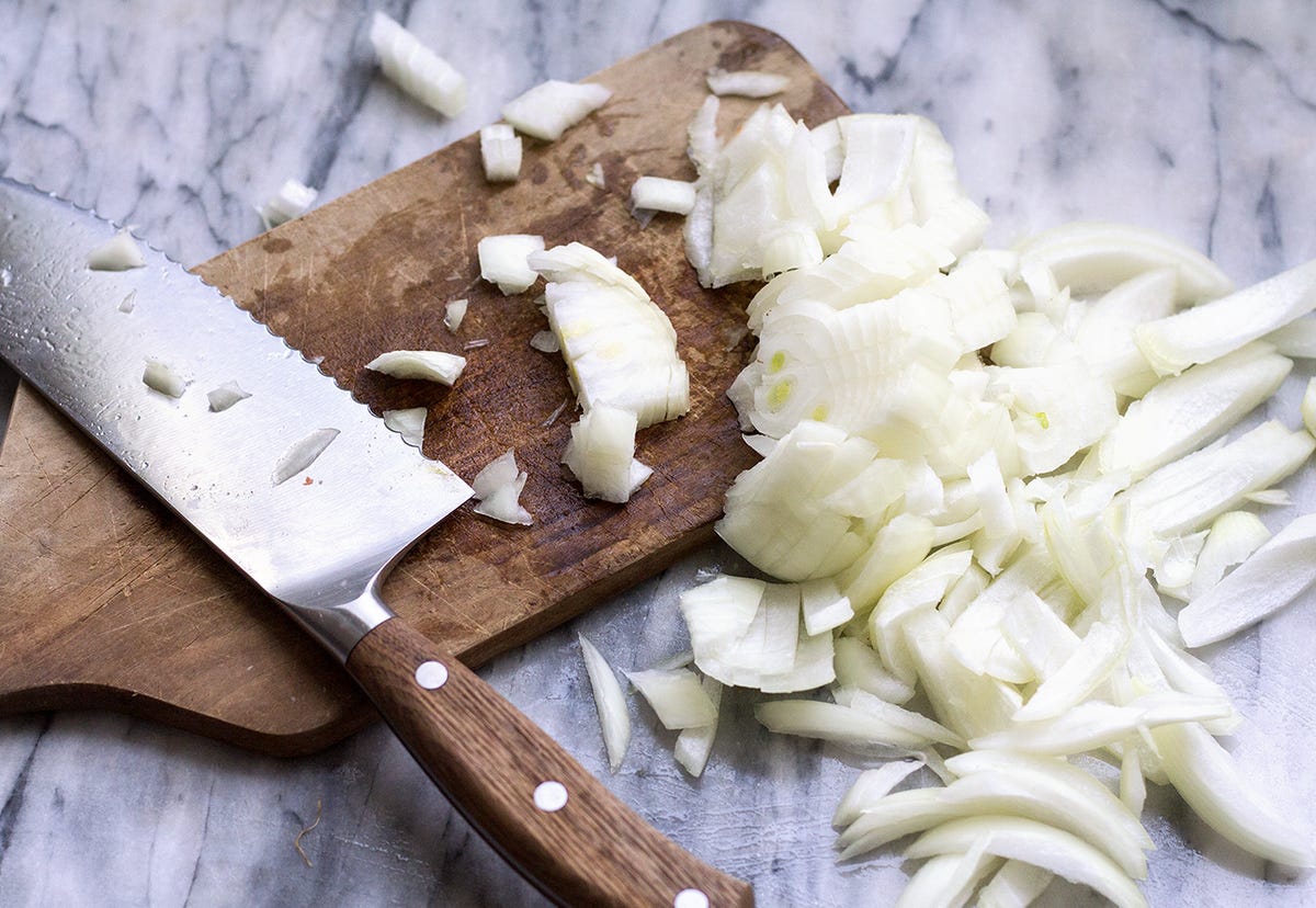 Cutting board with knife and onions Cutting board with knife and onions
