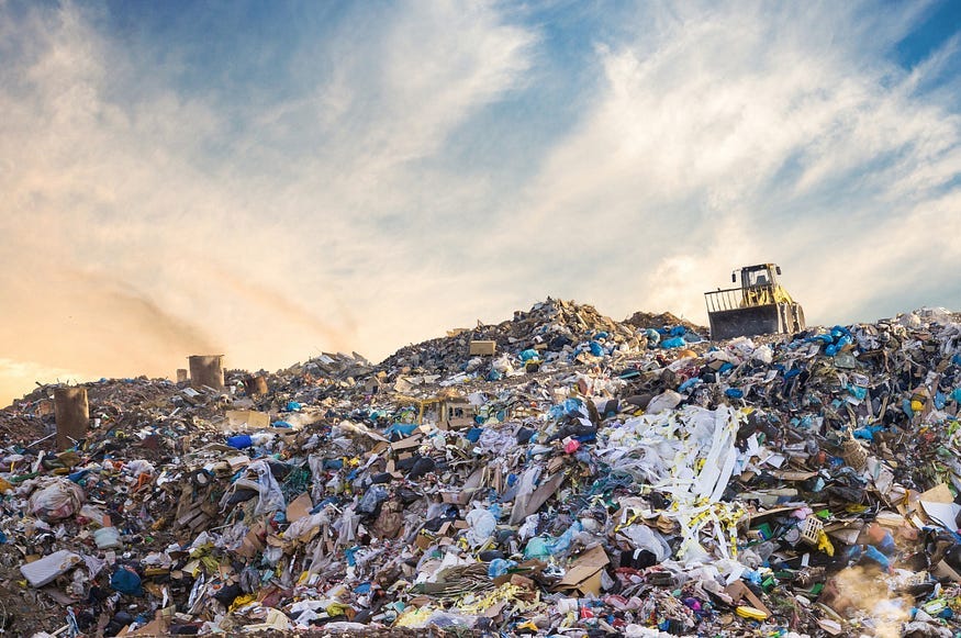 A huge garbage dump with a bucket-loader in the distance. A huge garbage dump with a bucket-loader in the distance.