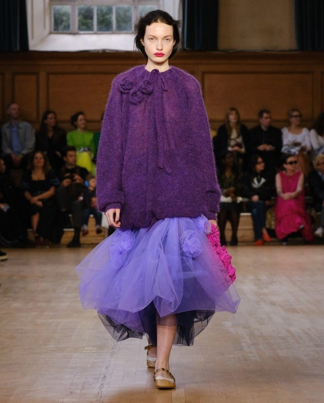 A person wearing a purple outfit

Description automatically generated