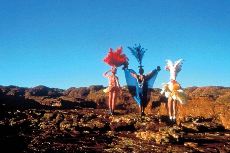 This may contain: three people dressed in costume standing on top of a rocky hill with their arms outstretched