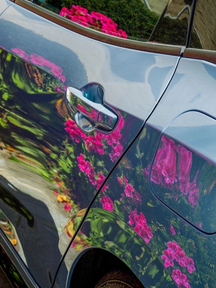 This may contain: a car with pink flowers painted on it's side