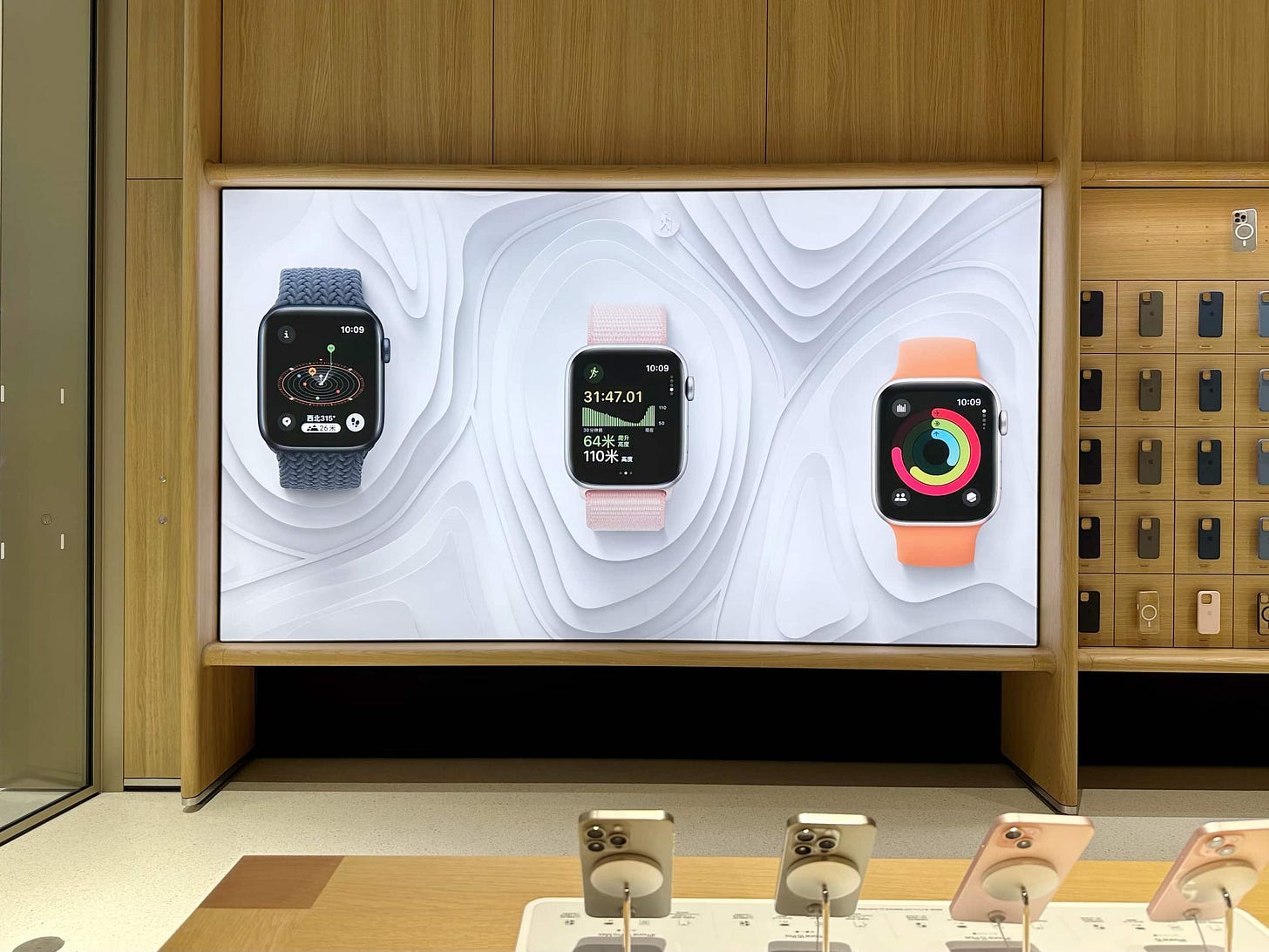 A holiday-themed graphic panel at Apple MixC Wenzhou. The image features three Apple Watches and a tiered, snowy white topographic backdrop. A holiday-themed graphic panel at Apple MixC Wenzhou. The image features three Apple Watches and a tiered, snowy white topographic backdrop.