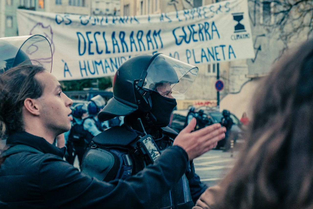 Participants and police forces during the occupation of the Praça do Chile at the end of the climate march in Lisbon