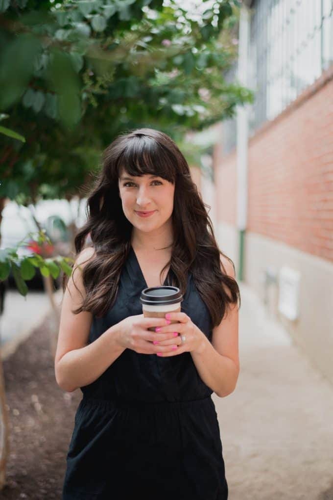 Liz smiles and holds a cup of coffee Liz smiles and holds a cup of coffee