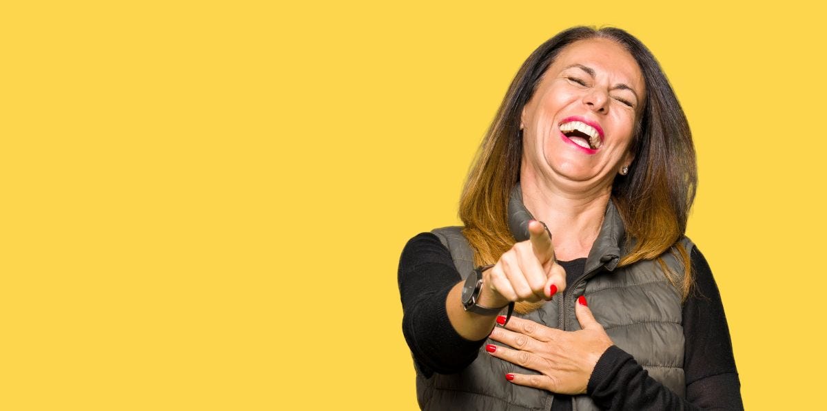Woman laughing, pointing at reader