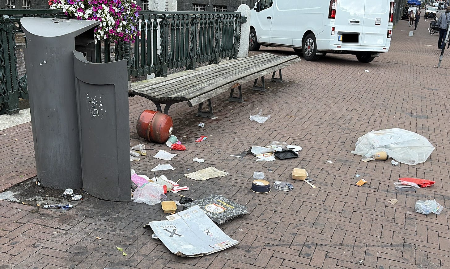 trash can in Amsterdam surrounded by disorderly litter on the street trash can in Amsterdam surrounded by disorderly litter on the street