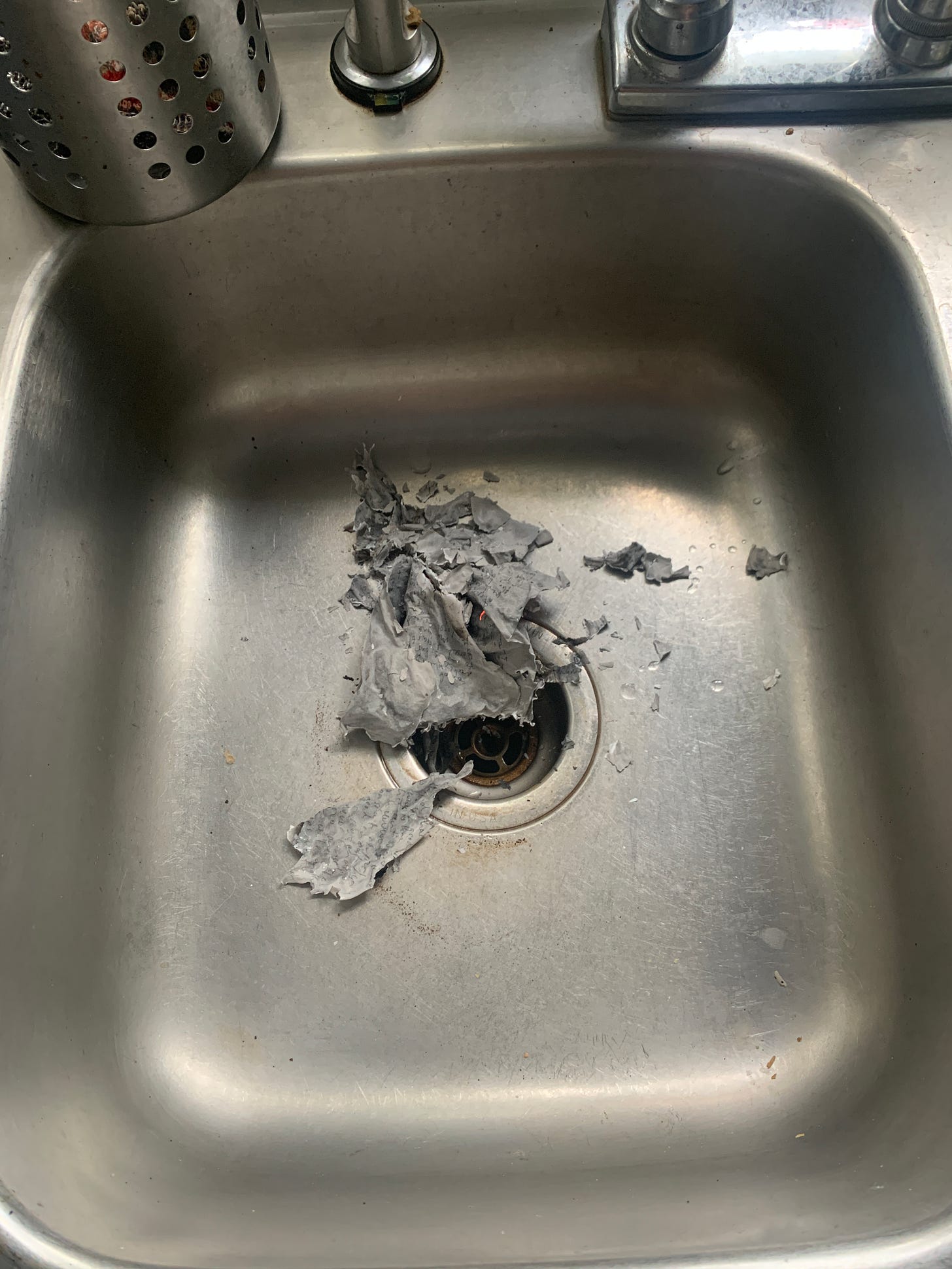 Ashes sit in the bottom of a stainless steel sink