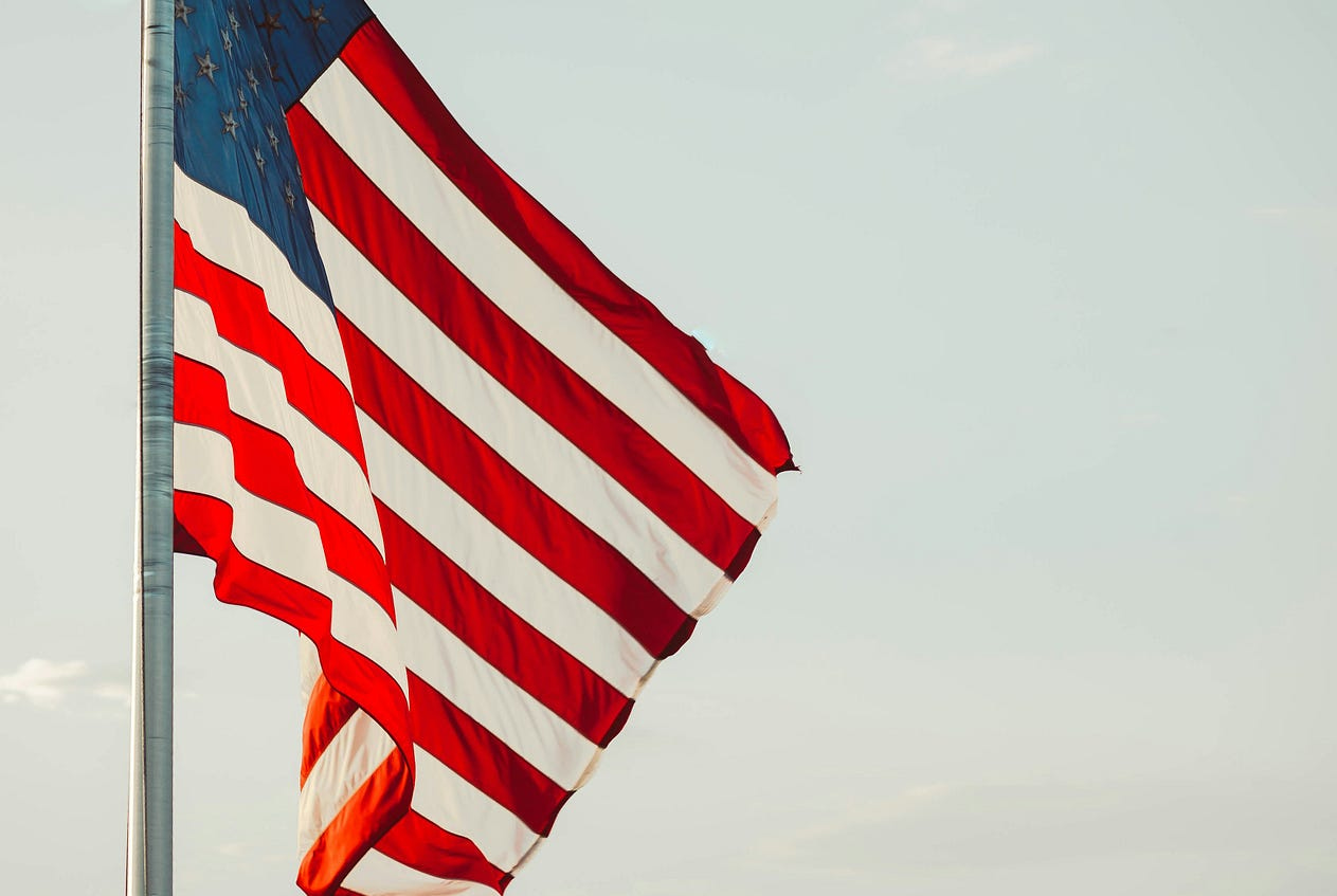 American flag blowing in the wind / Photo by James Balensiefen on Unsplash American flag blowing in the wind / Photo by James Balensiefen on Unsplash