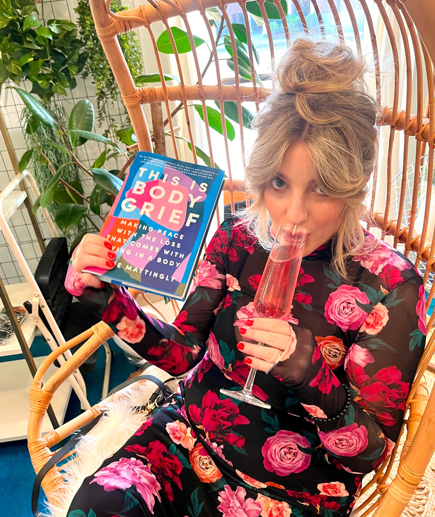 jayne holding her book THIS IS BODY GRIEF and drinking a celebratory drink 
