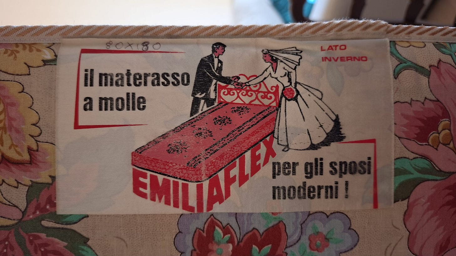 Etichetta sul materasso con l’immagine degli sposi e la scritta “EMILIAFLEX il materasso a molle per gli sposi moderni! LATO INVERNO“