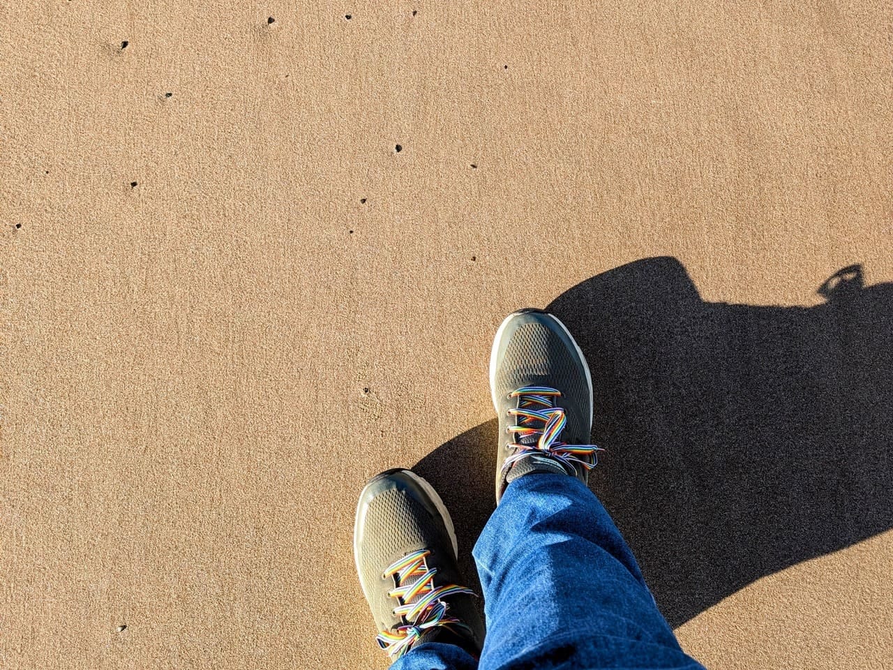 Looking down: standing on flat beach sand