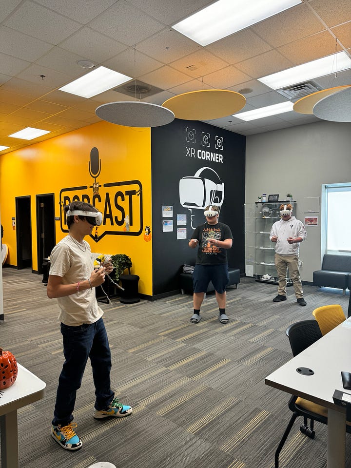 This is a gallery of 4 images of different students and staff wearing the Meta Quest 3's in the Colab doing different games/acitvites