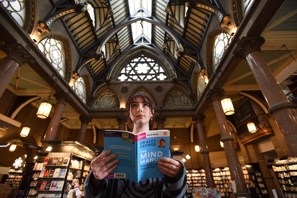 Person holding a book in the Wool Exchange, Bradford