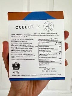 Chocolate bar with the title Miche Crumb and a stylised block print grain of wheat plus the reverse of the bar with the ingredients and nutritional information.