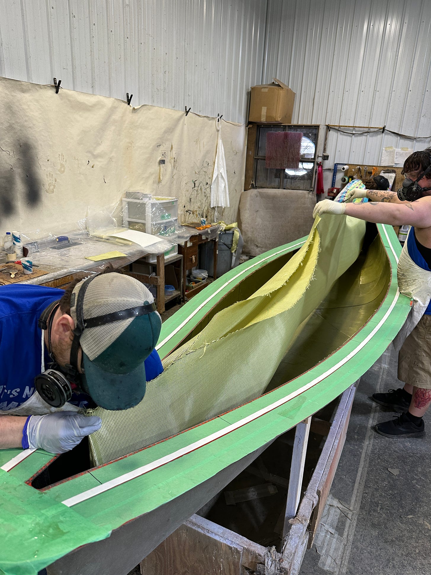 Putting Kevlar fabric into a canoe mold.