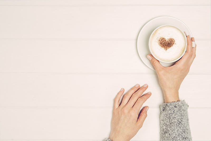 women holding a coffee cup with a heart