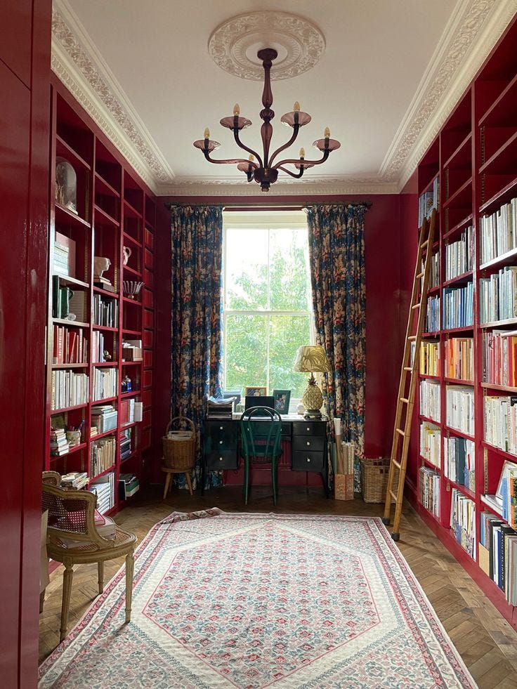 This may contain: a room with red bookcases filled with books and a rug on the floor