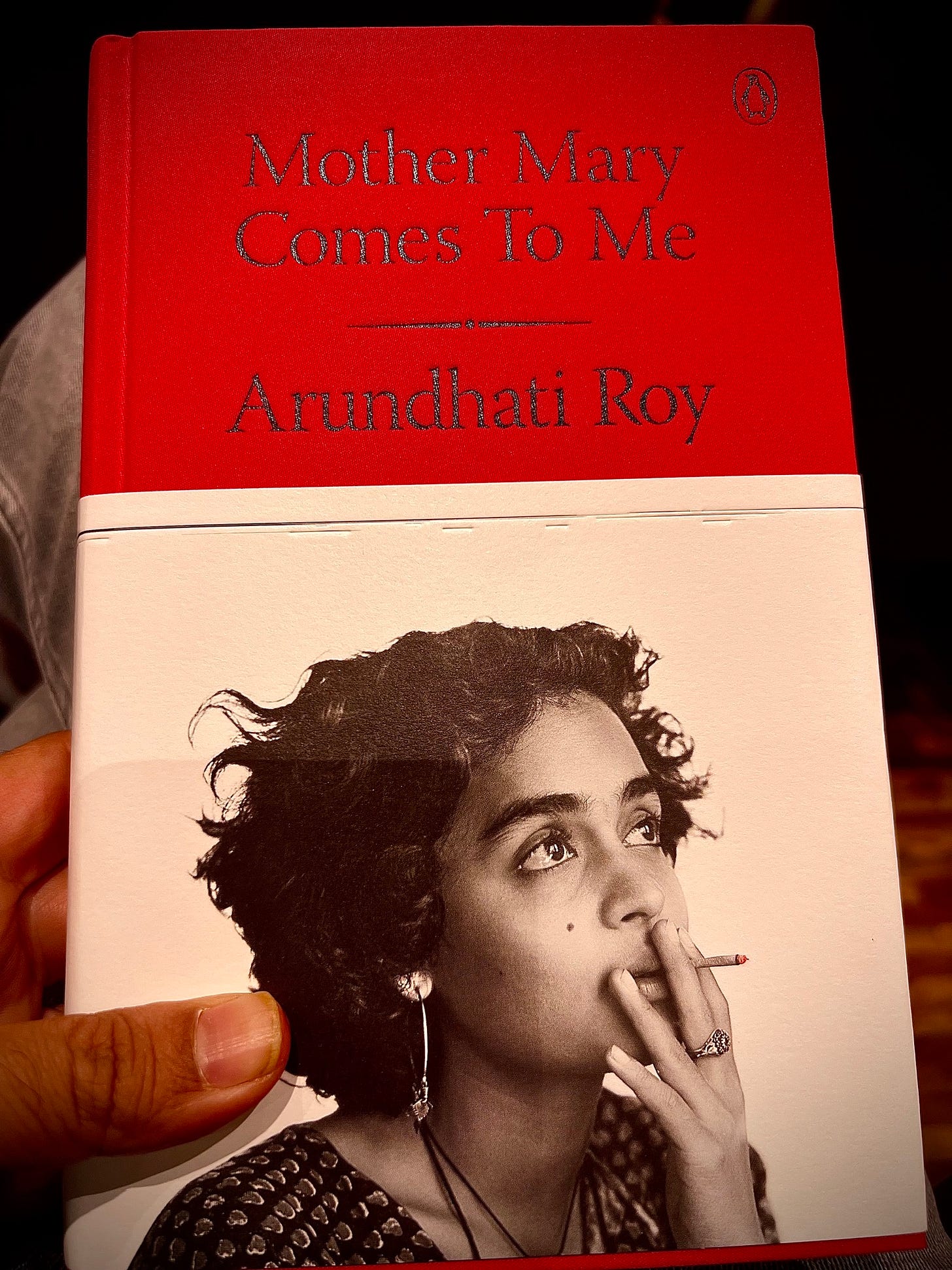May be an image of 1 person, lighter, diary and text that says "Mother Mary Comes Το ToMe Me Arundhatil Roy"