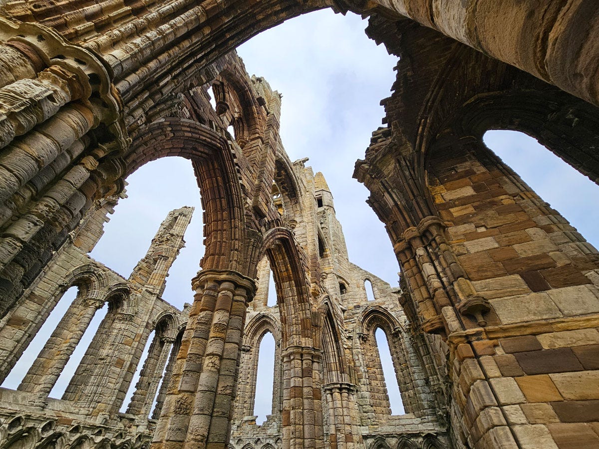 A view from below looking up through the open roof of a ruined stone building