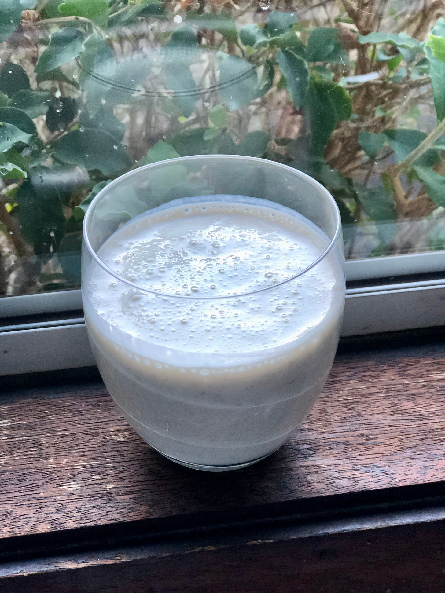 A banana smoothie on a window ledge