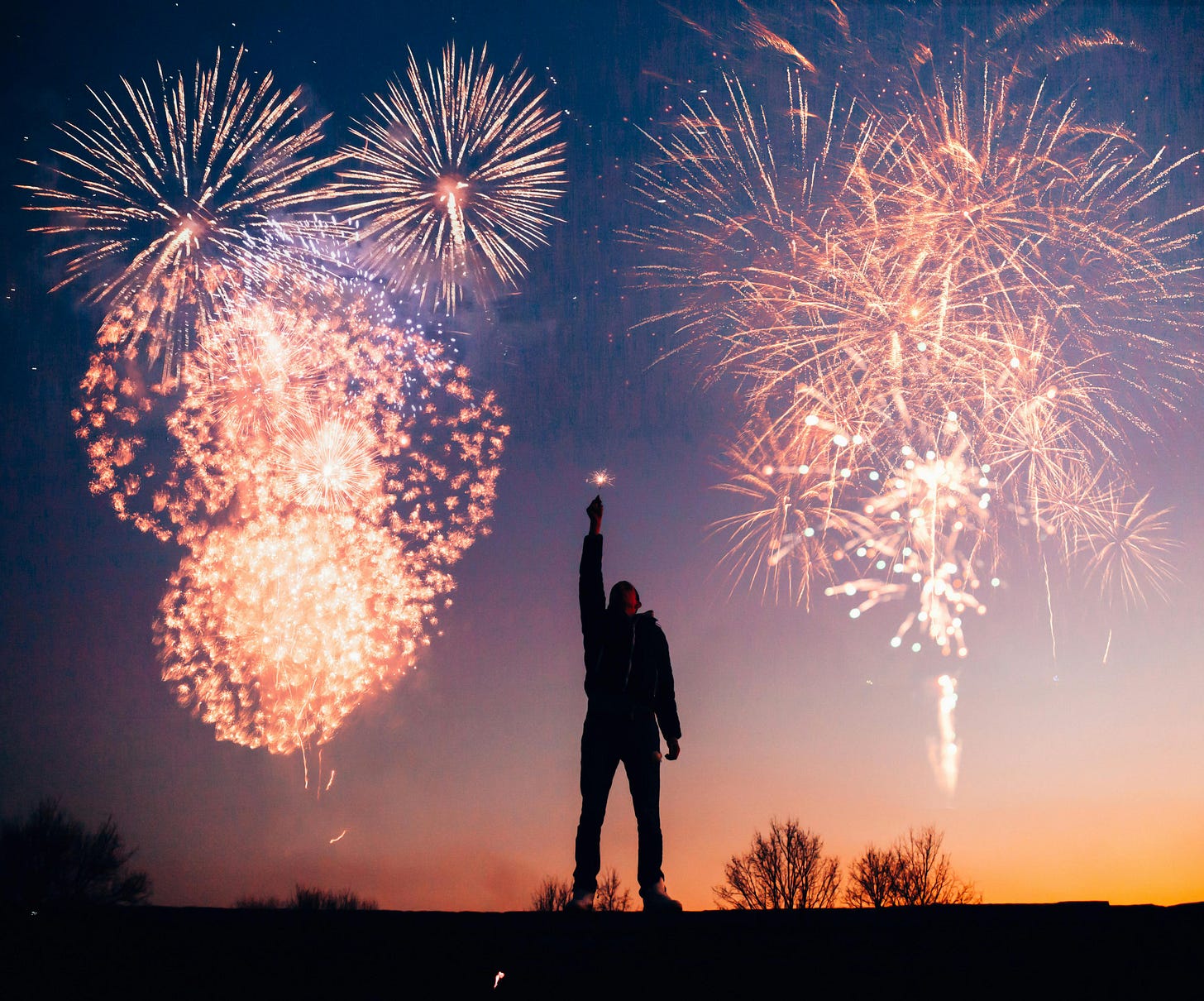 Free A person celebrates under vibrant fireworks in the evening sky in Kragujevac, Serbia. Stock Photo