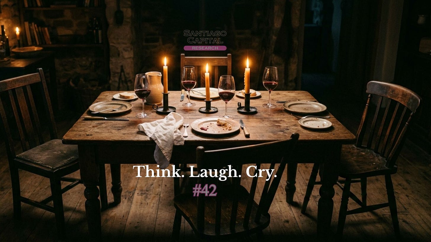 Rustic wooden dining table with candles, wine glasses, and plates in dimly lit room