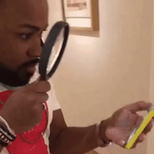 a man is looking at his phone through a magnifying glass . a man is looking at his phone through a magnifying glass .