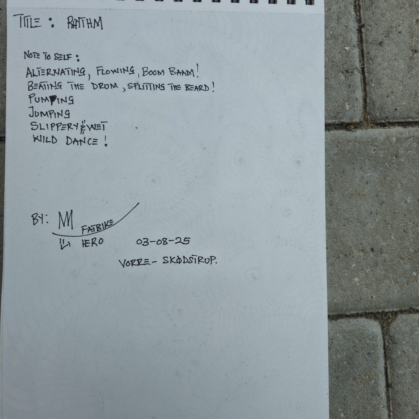 Handwritten notes on the back of a sketchbook page. Text reads: "TITLE: RHYTHM. NOTE TO SELF: ALTERNATING, FLOWING, BOOM BOOM! BEATING THE DRUM, SPLITTING THE BEARD! PUMPING JUMPING SLIPPERY WET WILD DANCE! BY: M FATBIKE HERO 03-08-25 VORRE - SKODSTRUP." Handwritten notes on the back of a sketchbook page. Text reads: "TITLE: RHYTHM. NOTE TO SELF: ALTERNATING, FLOWING, BOOM BOOM! BEATING THE DRUM, SPLITTING THE BEARD! PUMPING JUMPING SLIPPERY WET WILD DANCE! BY: M FATBIKE HERO 03-08-25 VORRE - SKODSTRUP."
