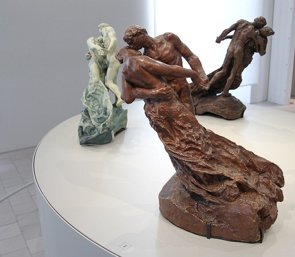 Three small statues, bronze and marble, of couples, with the female figure subsumed by the male