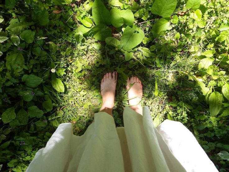 This may contain: a person standing in the grass with their feet up This may contain: a person standing in the grass with their feet up